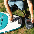 Person inflating a Taiga paddleboard with a battery pump