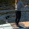 Person standing on a paddleboard, wearing a crewneck with 'Slow Rider Club' text.