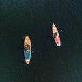 Two paddleboards on a body of water from an aerial perspective