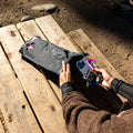 Person packing a black dry bag with keys and phone