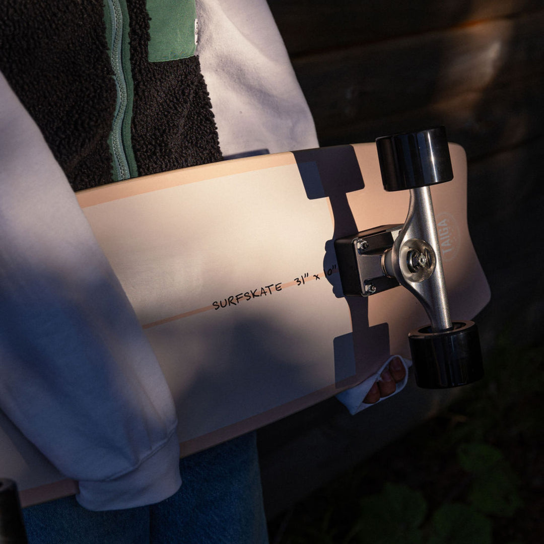 Close-up of a skateboard with 'Surfskate' branding on a blurred background