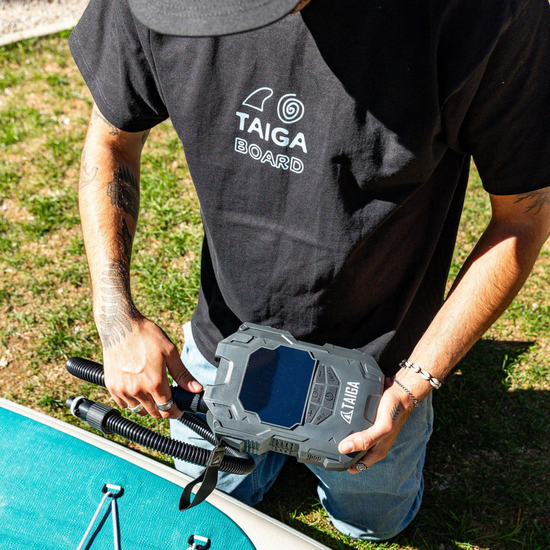 Person wearing a TAIGA BOARD t-shirt
