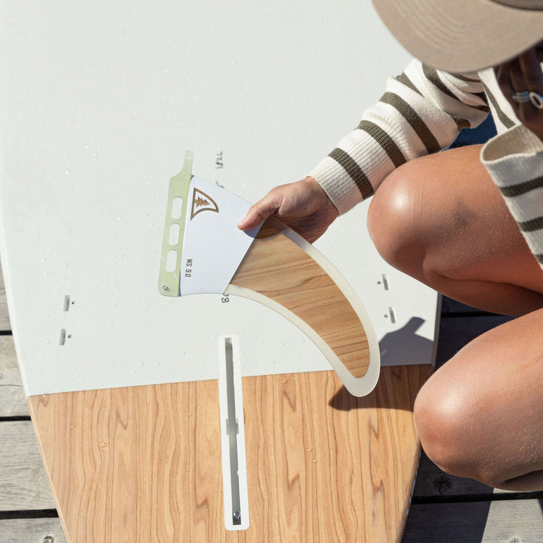 Person holding a central fin for a hard paddle board